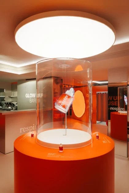 Hélice holographique sous cloche transparente affichant un flacon en 3D dans une boutique